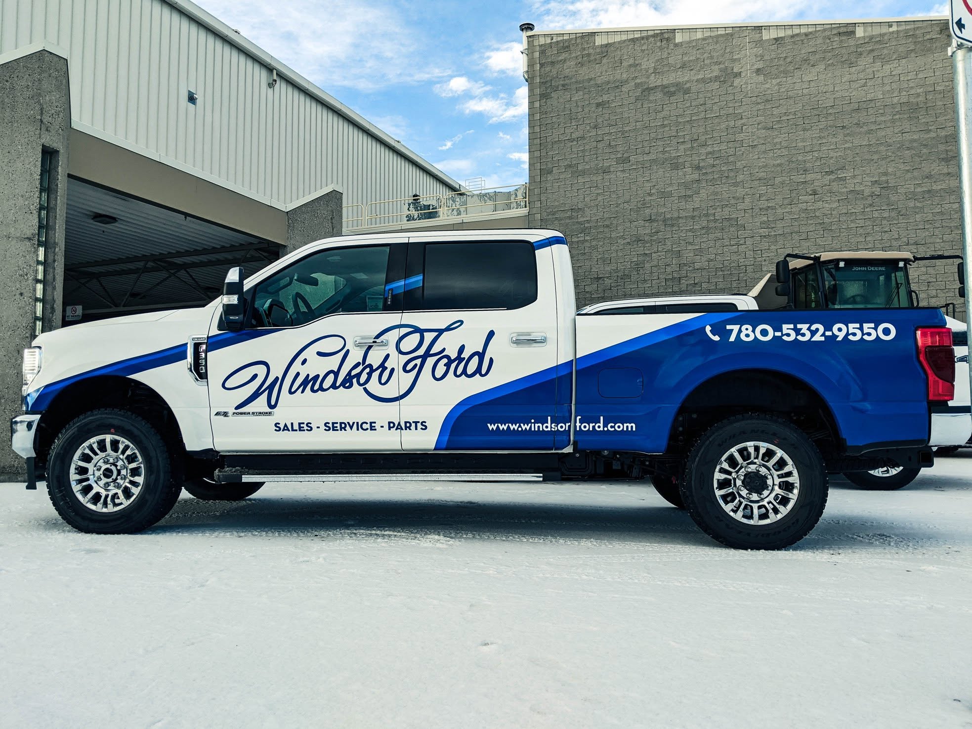 A Windsor Ford branded truck with the dealership wrap and phone number