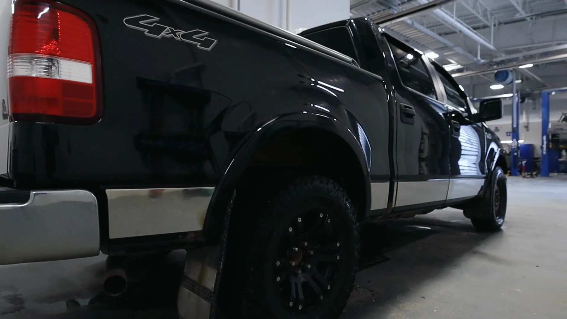 A freshly detailed black Ford F-150, rear three-quarter view, in the Windsor Ford detail bay